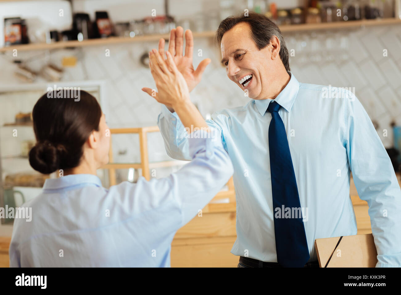 Senior uomo soddisfatto esultanza e dando cinque al collega. Foto Stock