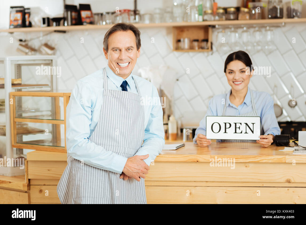 Gentile uomo senior appoggiata al bar e sorridente. Foto Stock