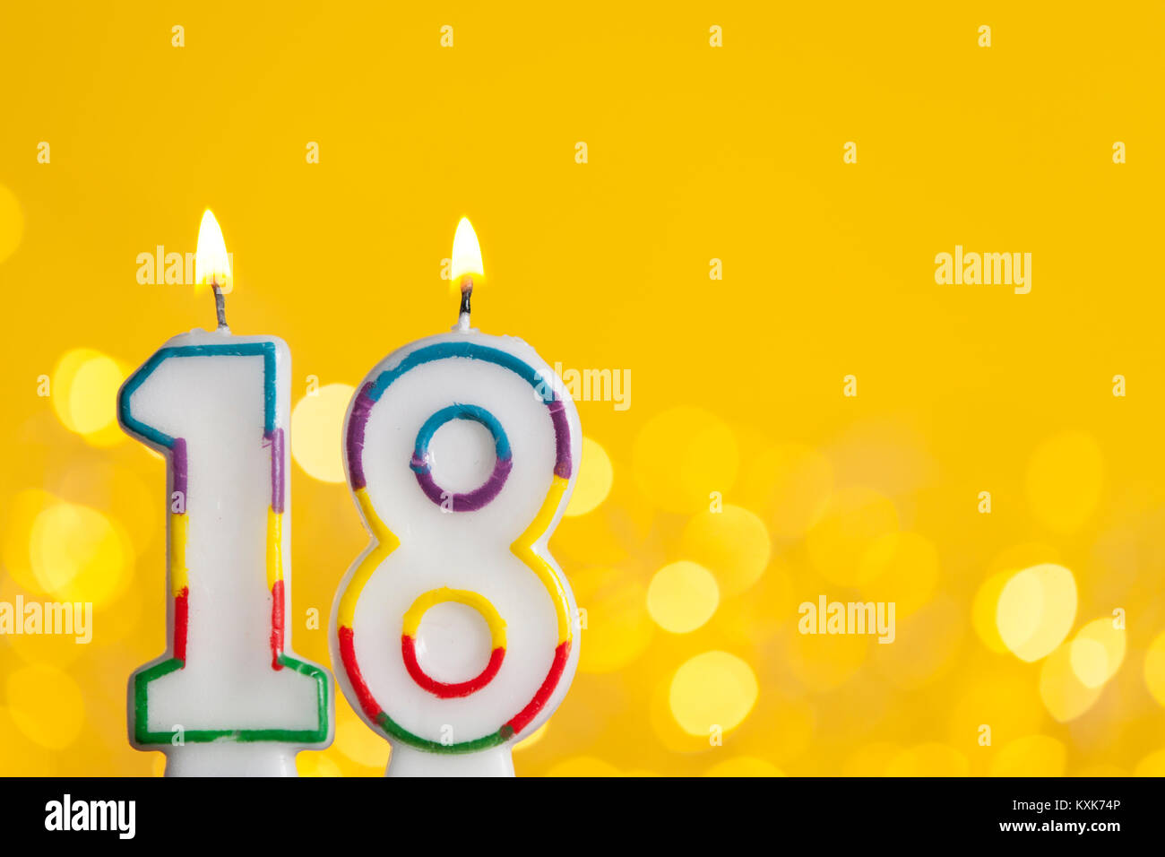 Numero 18 Celebrazione Di Compleanno Candela Contro Un Luci Luminose E Sfondo Giallo Foto Stock Alamy