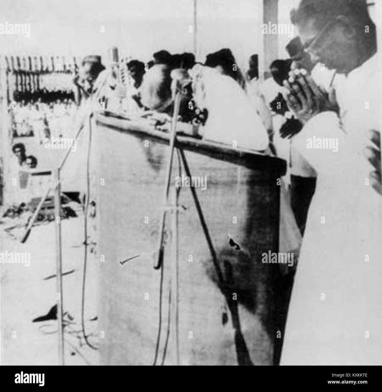 Illustrazione intitolata “Un gigante di un uomo che si inchina davanti al Buddha!” Raffigura una grande figura umana inginocchiata davanti a una statua del Buddha, evidenziando il contrasto in scala e i temi dell'umiltà davanti alle icone spirituali. Foto Stock