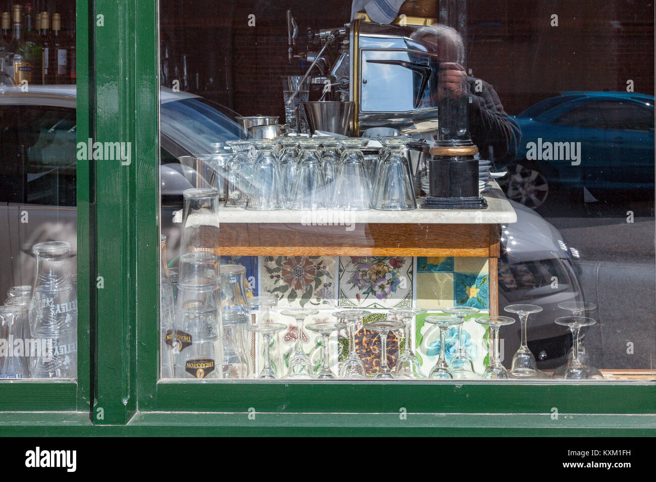Un display di occhiali, piastrelle colorate e una macchina da caffè nella finestra di un cafè sul pesce Quay, North Shields, Regno Unito Foto Stock