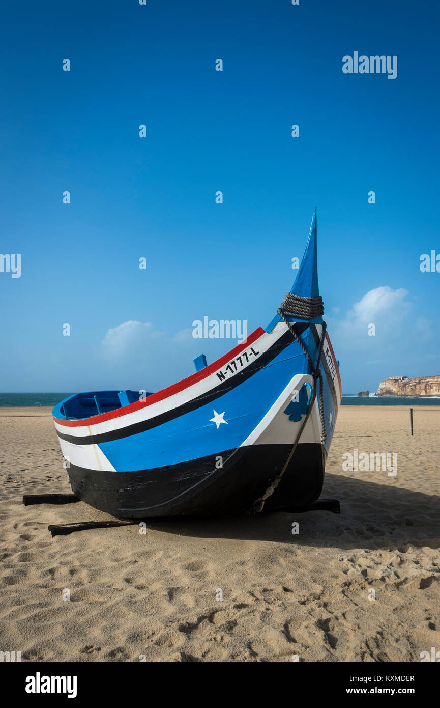 Blu tradizionale barca da pesca sulla riva a Nazare, Portogallo Foto Stock