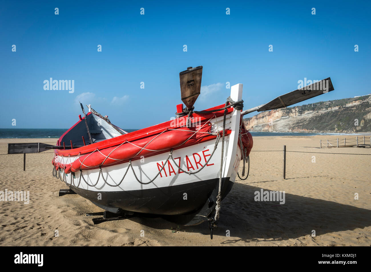 Tradizionale in rosso e bianco verniciato scialuppa di salvataggio sulla spiaggia a Nazare, Portogallo. Foto Stock