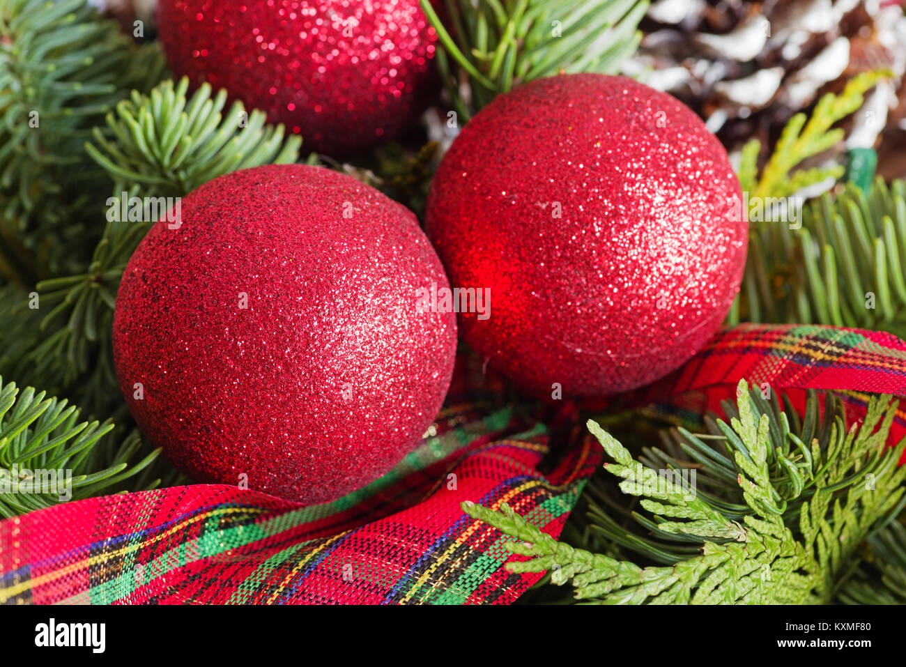 Red scintillanti decorazioni di Natale con rami di pino e il nastro di inchiostro Foto Stock