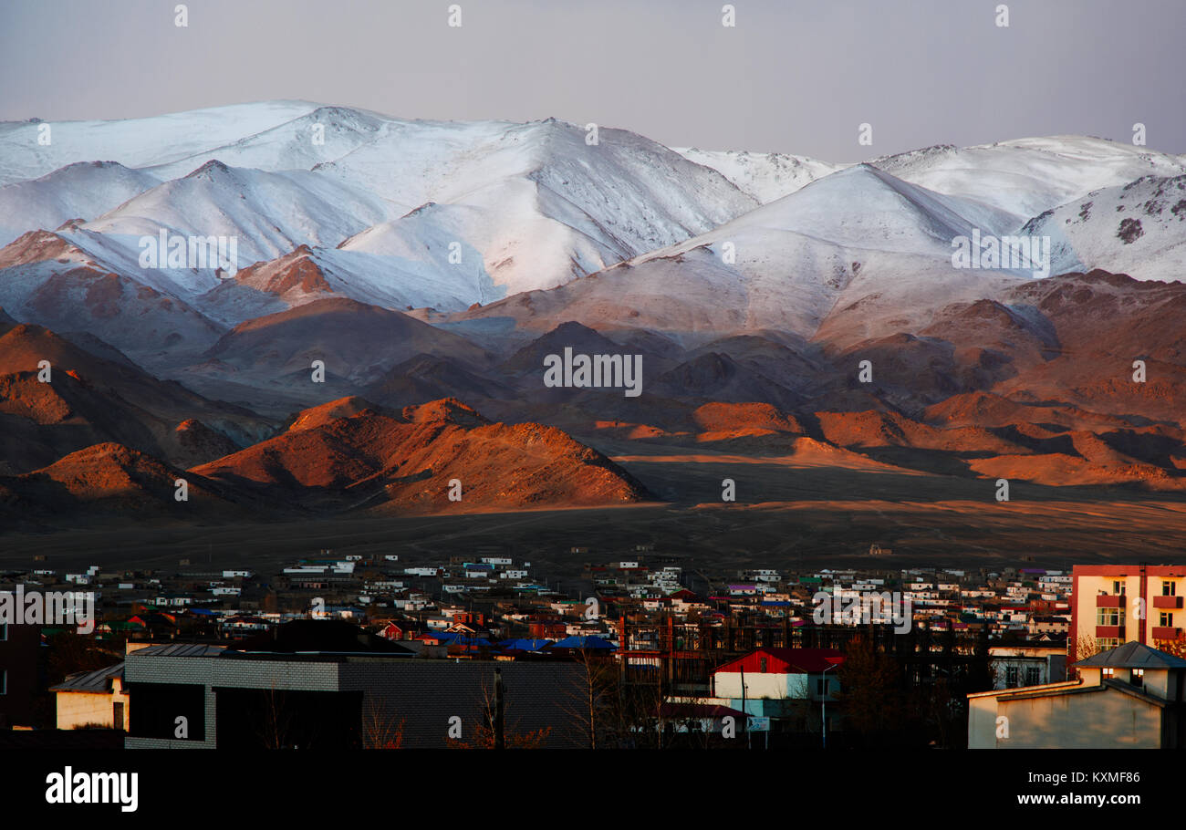 Il bayan Ulgii Ölgii city town montagne innevate sunrise rosso chiaro montagne creste bianco neve Foto Stock
