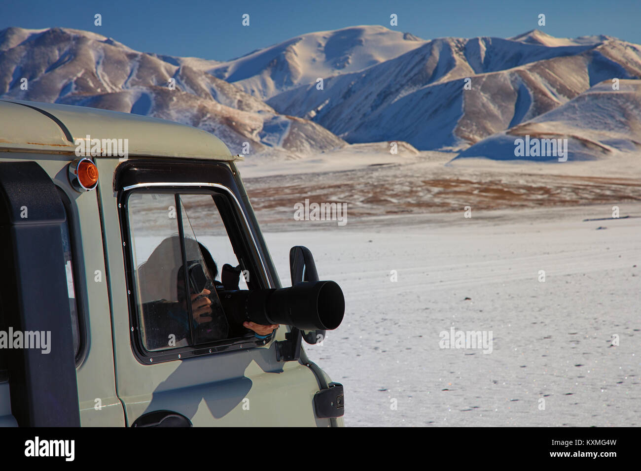 Ragazza fotografare il russo van UAZ 452 camper dslr lengs zoom sigma 150-600mm neve inverno Mongolia montagne innevate ora d'oro Foto Stock