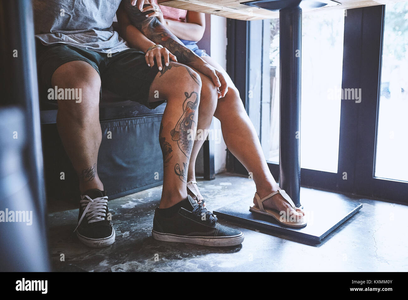 Vita scende di multi etnico hipster matura in cafe con la mano su ogni altro ginocchio,Shanghai Concessione Francese,Shanghai, Cina Foto Stock