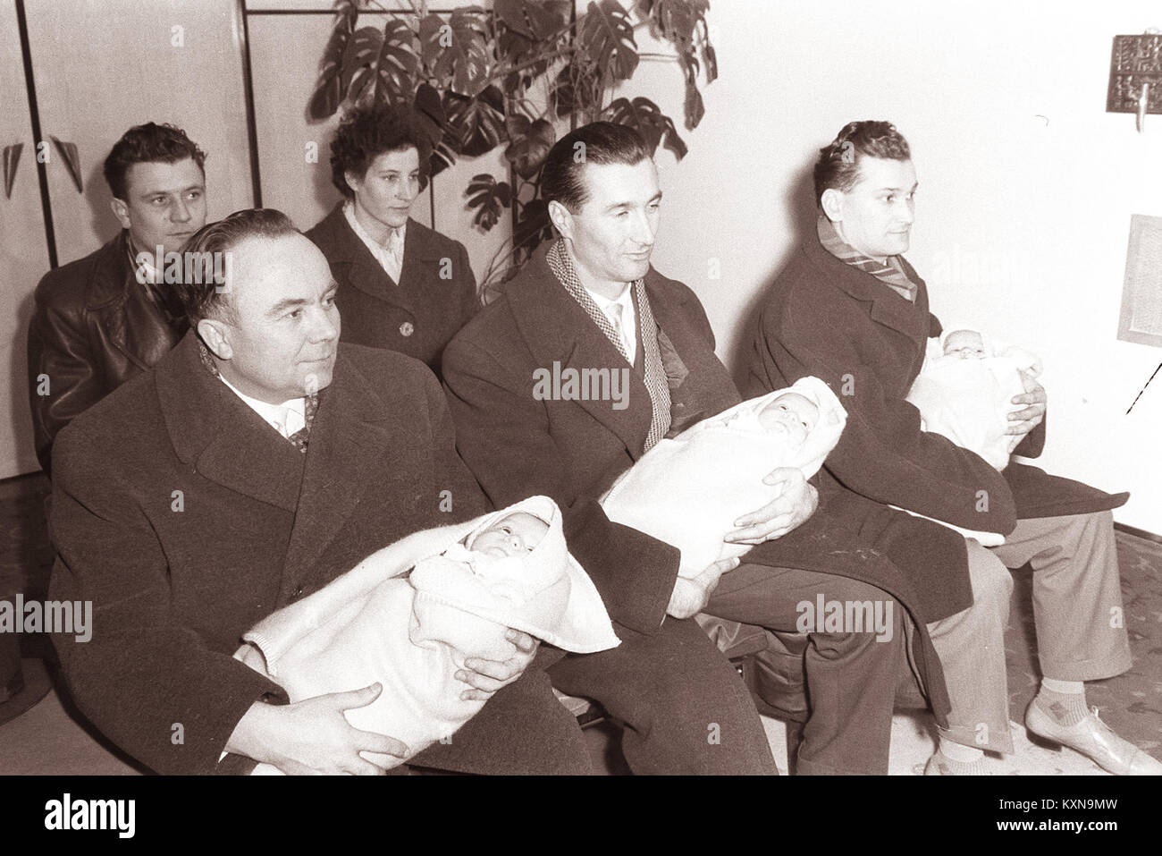 Una fotografia del 1962 che mostra il battesimo dei tripletti nella nuova sala matrimoni di Rotovž, evidenziando le pratiche religiose e culturali nella comunità locale. Foto Stock