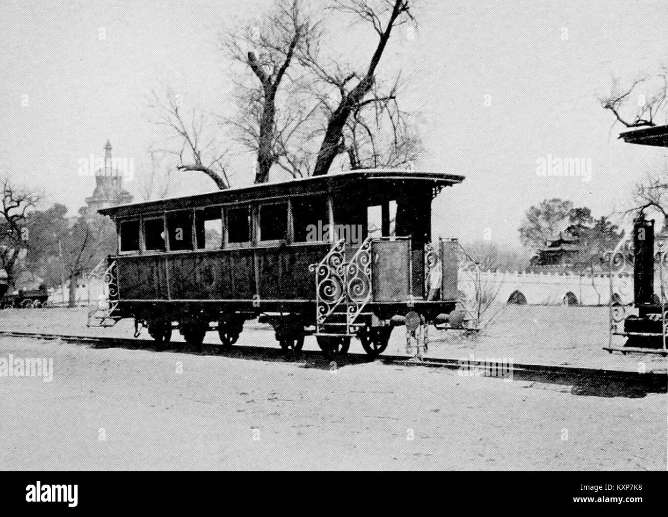 Questa immagine contrasta un tempio buddista tradizionale con un moderno tram, che illustra la coesistenza del patrimonio culturale e lo sviluppo urbano nella società contemporanea. Foto Stock