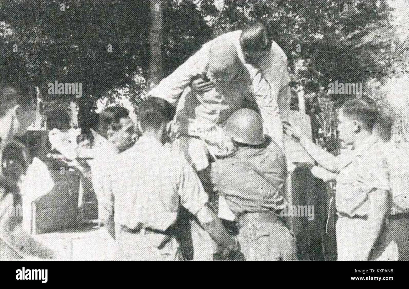 Questa immagine raffigura un uomo cinese portato in ospedale, parte di una serie che documenta le conseguenze di un conflitto o di una battaglia in Indonesia, riflettendo l'impatto umano della guerra. Foto Stock