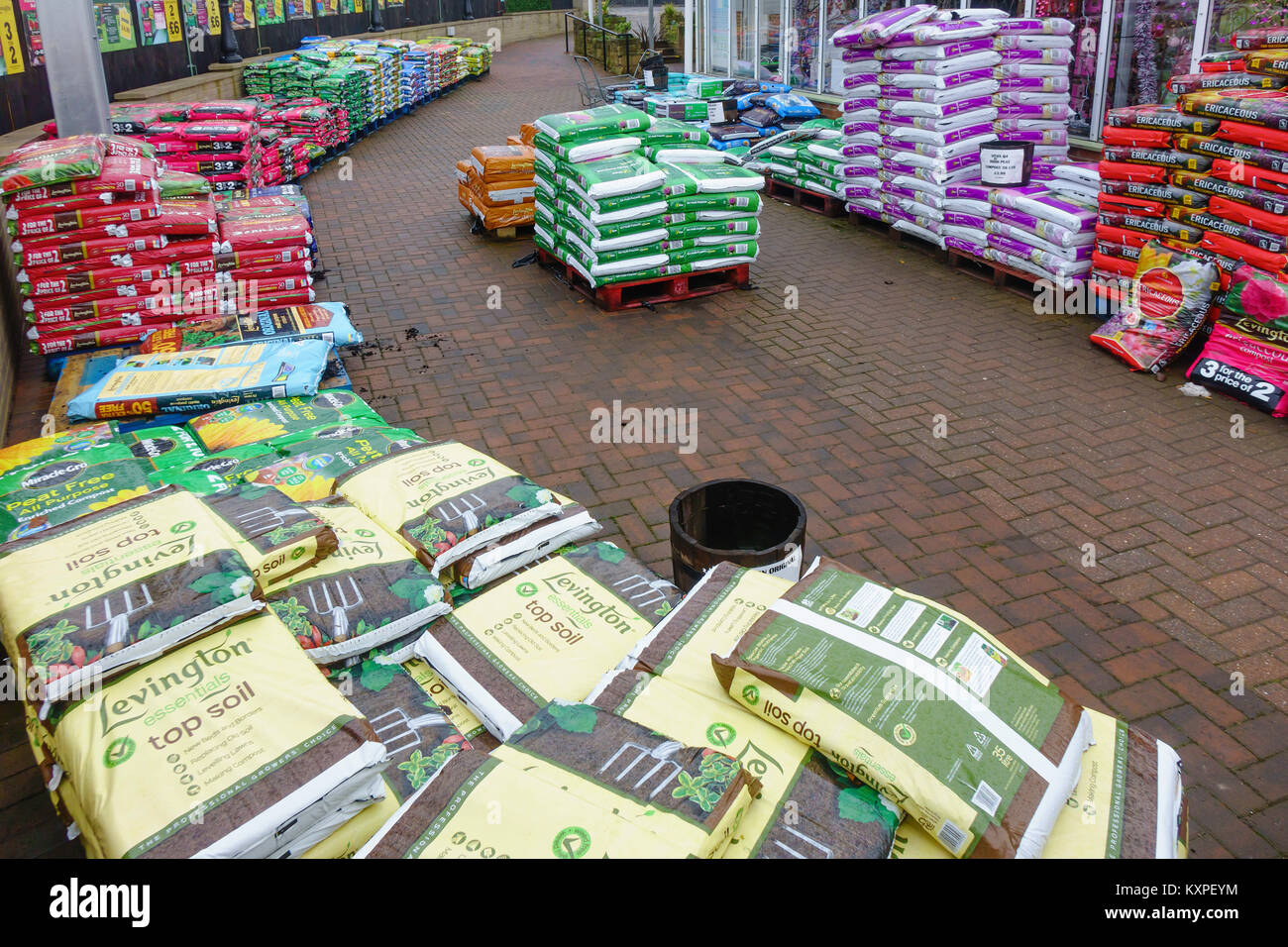 Un display di grandi dimensioni delle pile di sacchetti di terreno superiore, compost torba e corteccia in un garden center Foto Stock