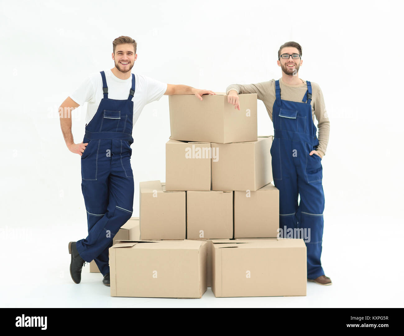 Giovani uomini che trasportano una casella per la pila di scatole. Foto Stock