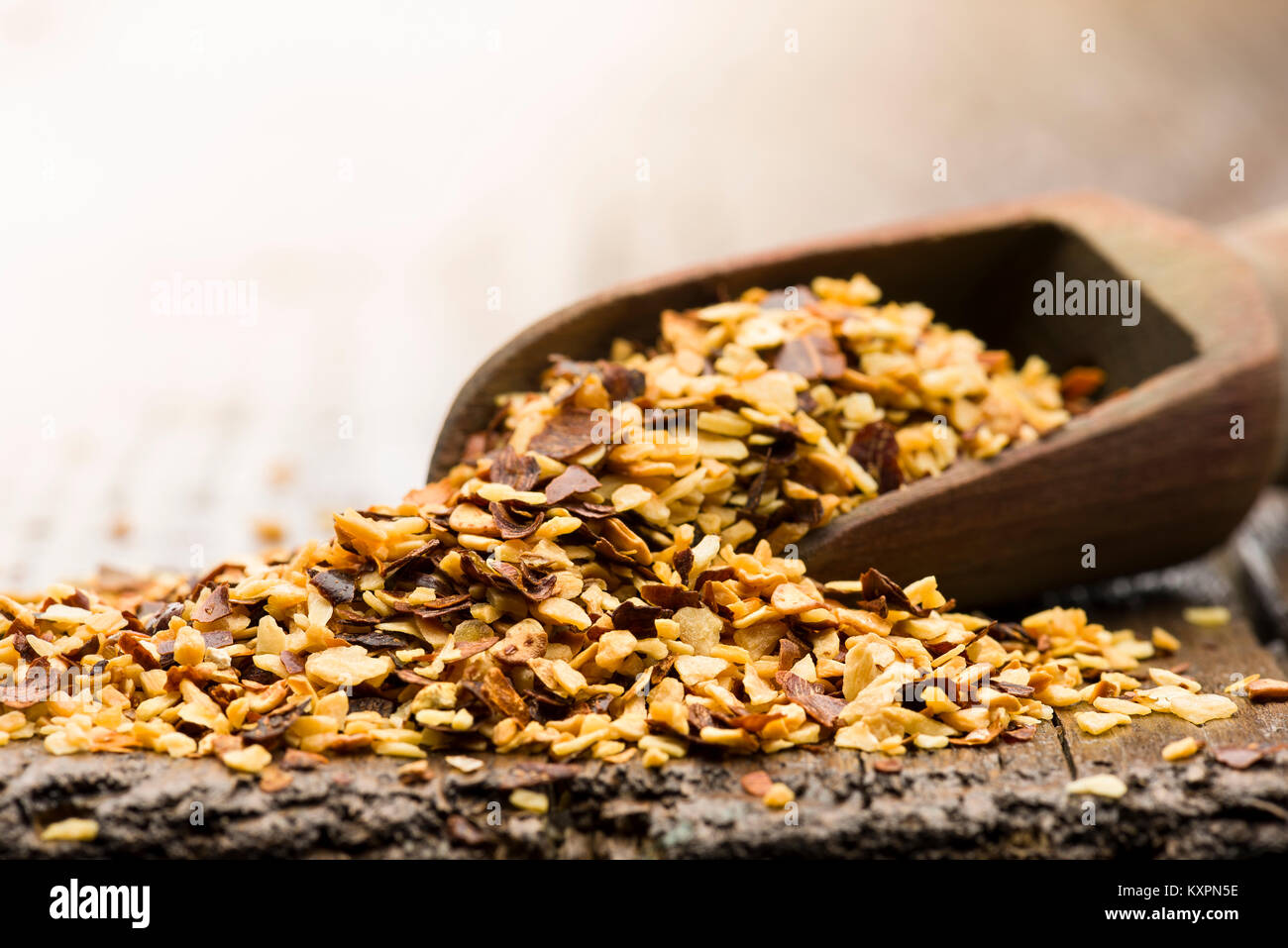 Cucchiaio di legno con secchi peperoncino e aglio sul tavolo Foto Stock