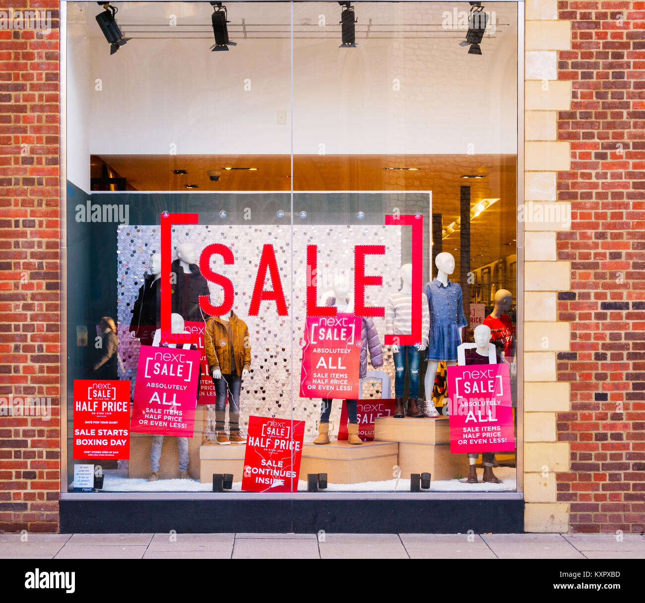 Gli avvisi di vendita intonacata nella finestra del prossimo negozio nel centro della città a Cambridge, Inghilterra. Foto Stock