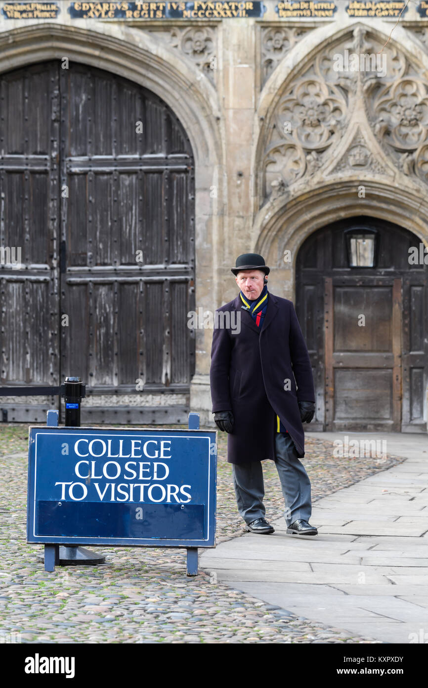 La guardia di sicurezza con cappello bowler sta di guardia all'entrata al Trinity College, Università di Cambridge, Inghilterra. Foto Stock