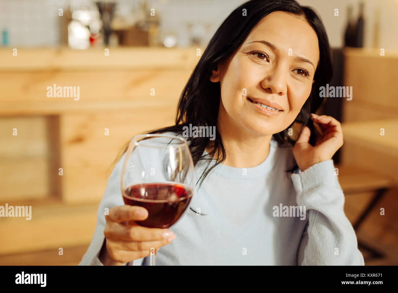 Donna esuberante di bere vino rosso Foto Stock