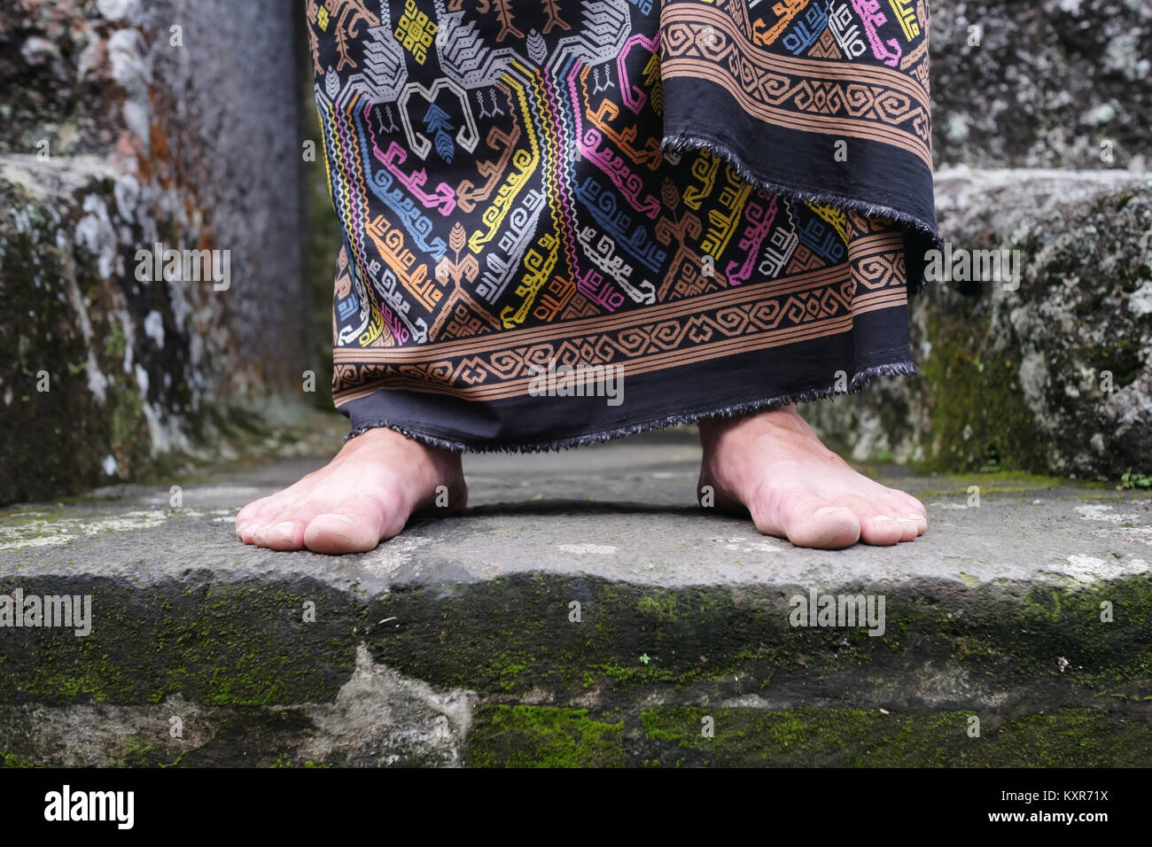 Vista ravvicinata sul piede uomo in stile balinese sarong indonesiano. Foto Stock