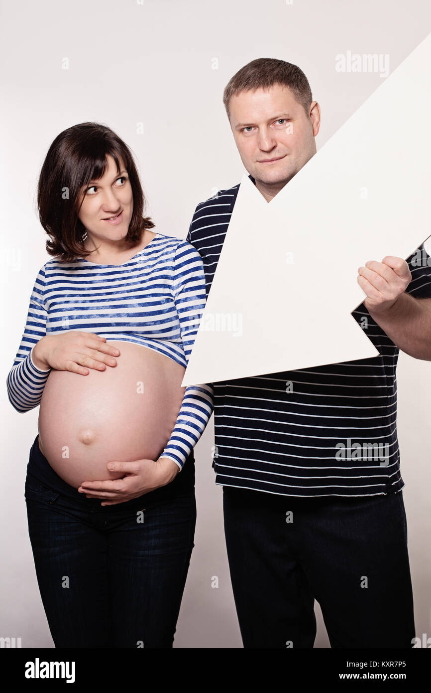 Carino donna incinta e Uomo con segno di freccia. Amore parentale e il concetto di cura Foto Stock