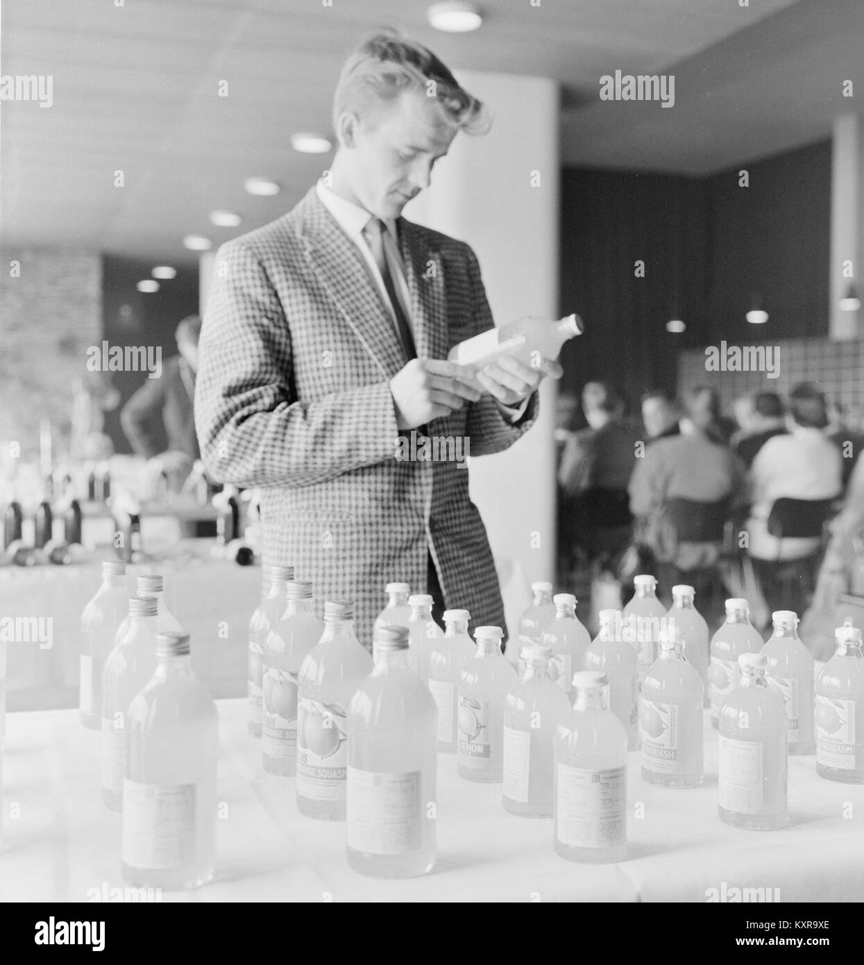 Uomo con bottiglie di bevande analcoliche prodotte in una fabbrica, Finlandia 1959 Foto Stock