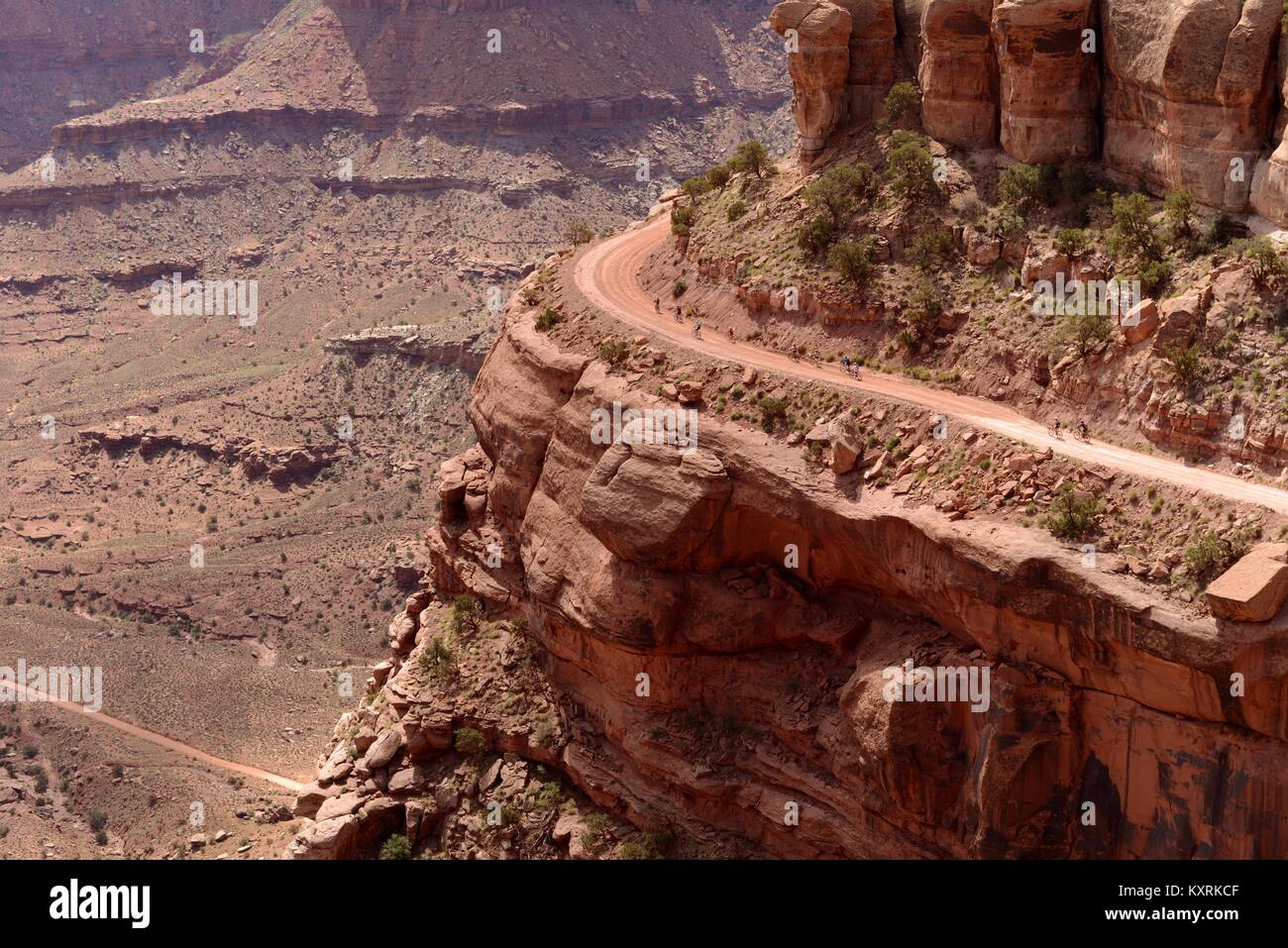 Percorsi in bicicletta sul bordo della scogliera - un gruppo di motociclisti sono a cavallo su una scogliera ripida strada (Shafer Canyon Trail) nel Parco Nazionale di Canyonlands, Moab, Utah, Stati Uniti d'America. Foto Stock