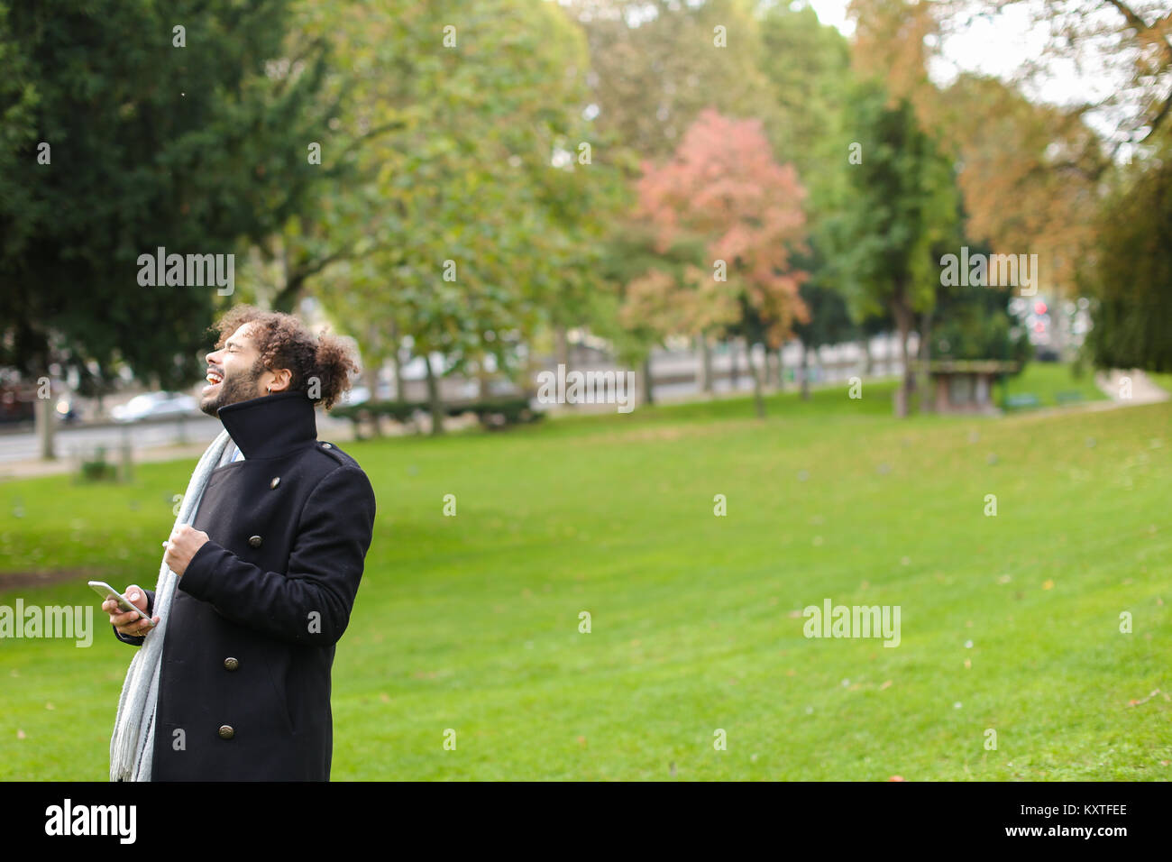 Uomo ispanico chiacchierando con la fidanzata sullo smartphone nel parco. Foto Stock