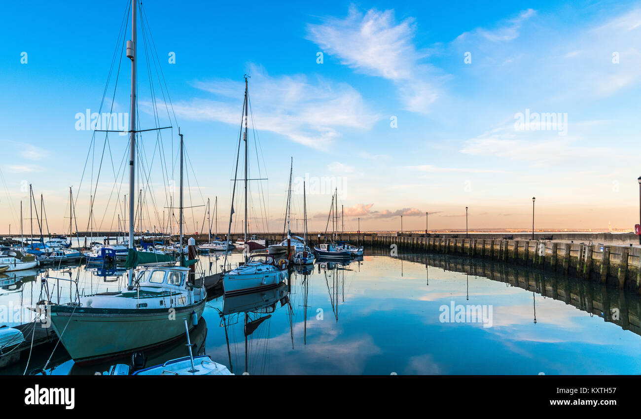 Riflessioni del porto. Cielo e nubi riflessi a Ryde Harbour, vicino al tramonto, Isola di Wight. Foto Stock