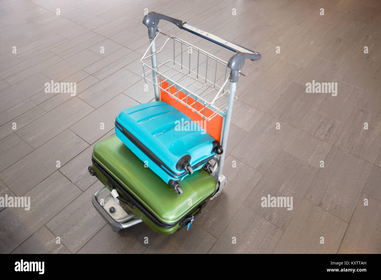 Alta Vista angolo di verde e di blu bagagli nel carrello di servizio in aeroporto Foto Stock