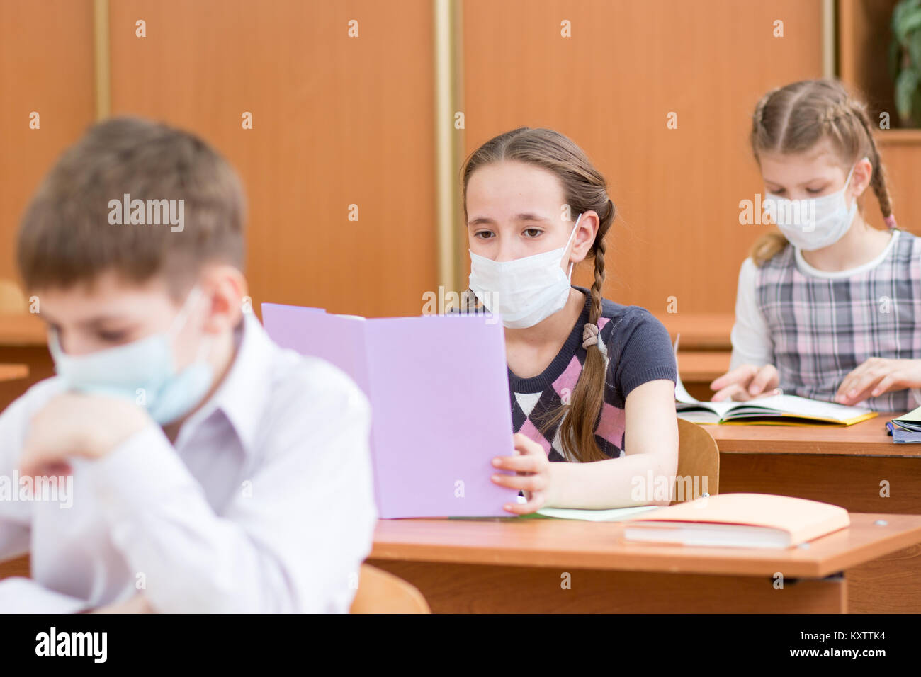 La scuola dei bambini con la maschera di protezione contro virus influenzale a lezione in aula Foto Stock