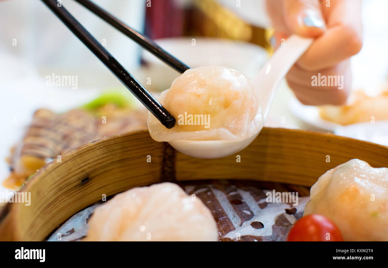 Ragazza tenendo i gamberi gnocco con bacchette in un ristorante Foto Stock