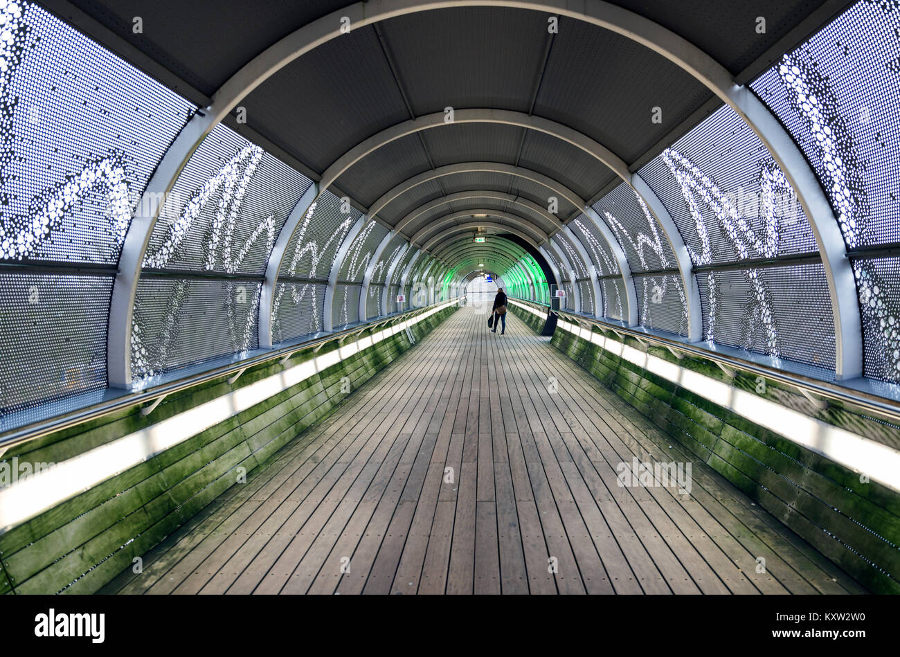 La gente camminare nel tunnel con luci Foto Stock