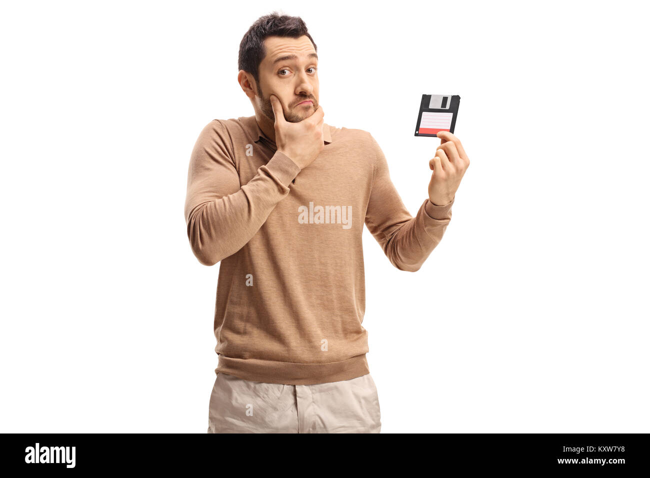 Confuso giovane tenendo un floppy disk isolati su sfondo bianco Foto Stock