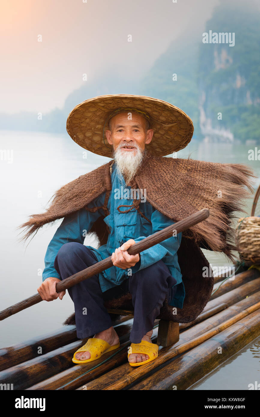 Cormorano pescatore e i suoi uccelli sul fiume Li in Yangshuo, Guangxi, Cina. Foto Stock