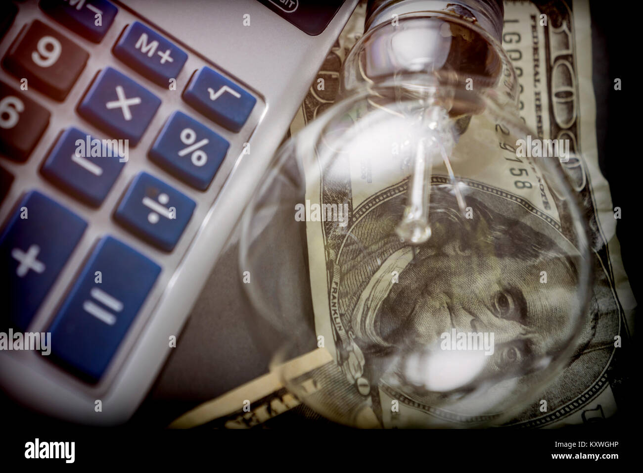 Calcolatrice e denaro accanto a una lampadina, il concetto di risparmio energetico Foto Stock