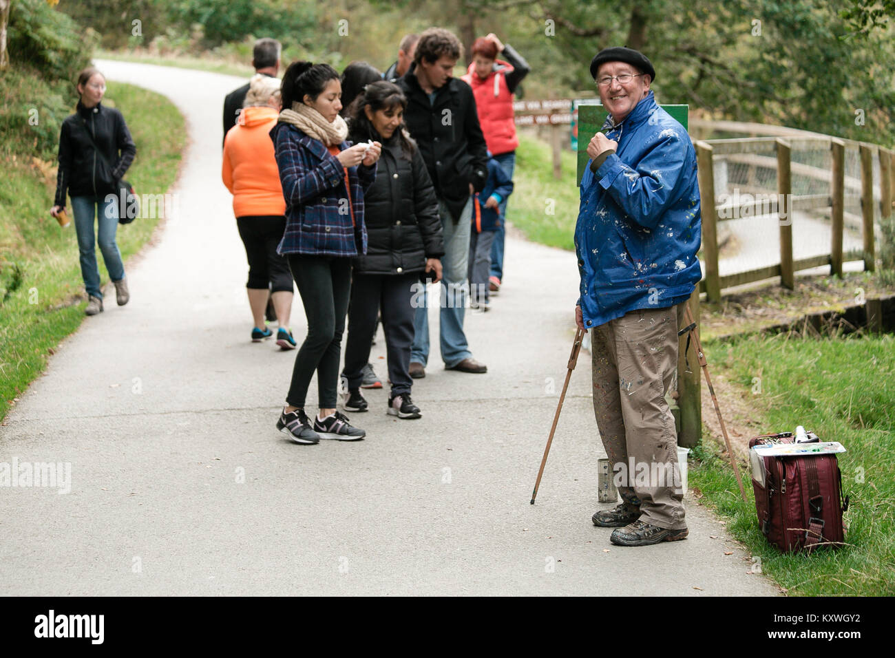 Artista pittore dipinto il paesaggio naturale nella valle di Glendalough ipnotiche passando per i turisti con la sua splendida opera d'arte Foto Stock