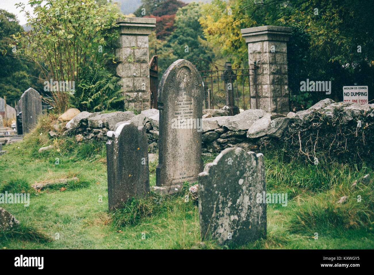 Vecchie lapidi nel cimitero situato sul sito monastico di Glendalough risalente al VI secolo Foto Stock