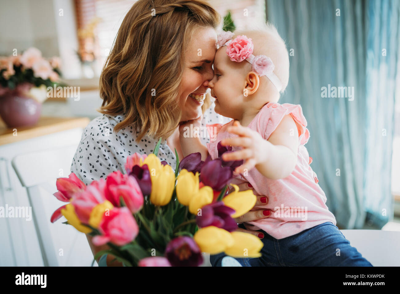 Figlia del bambino si congratula con le mamme e dà i suoi fiori Foto Stock