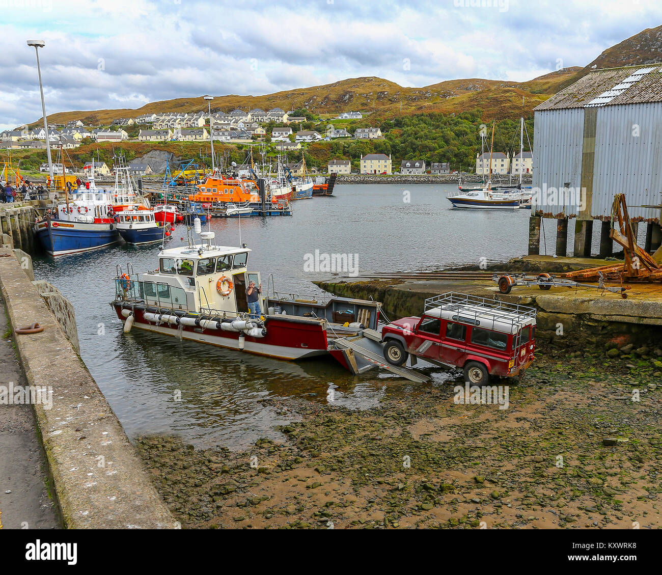 Caricamento di un Land Rover su una barca nel porto di Mallaig, Lochaber, sulla costa occidentale delle Highlands della Scozia, Regno Unito Foto Stock