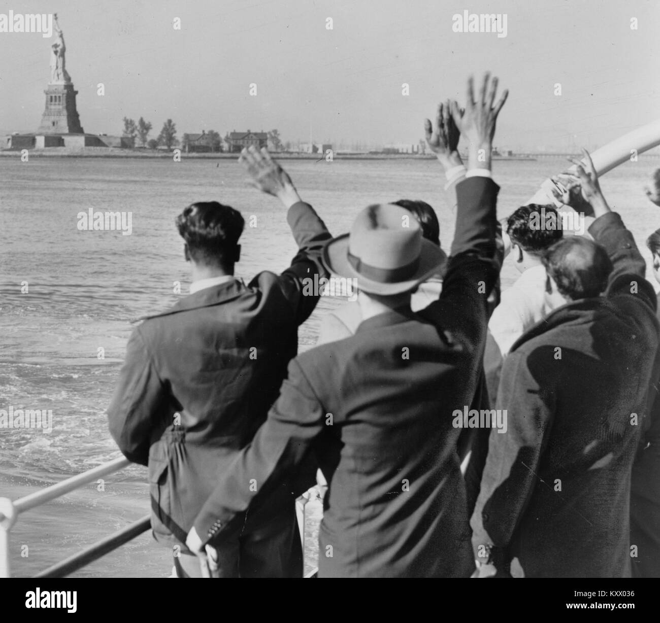 Gruppo di deportati onde addio alla Statua della Libertà Foto Stock