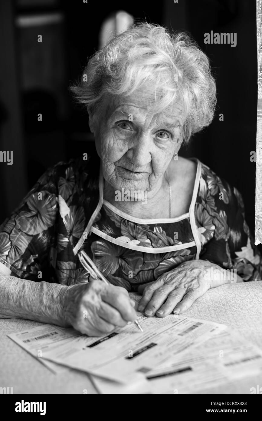 Donna anziana si riempie di entrate per servizi di pubblica utilità. Foto Stock
