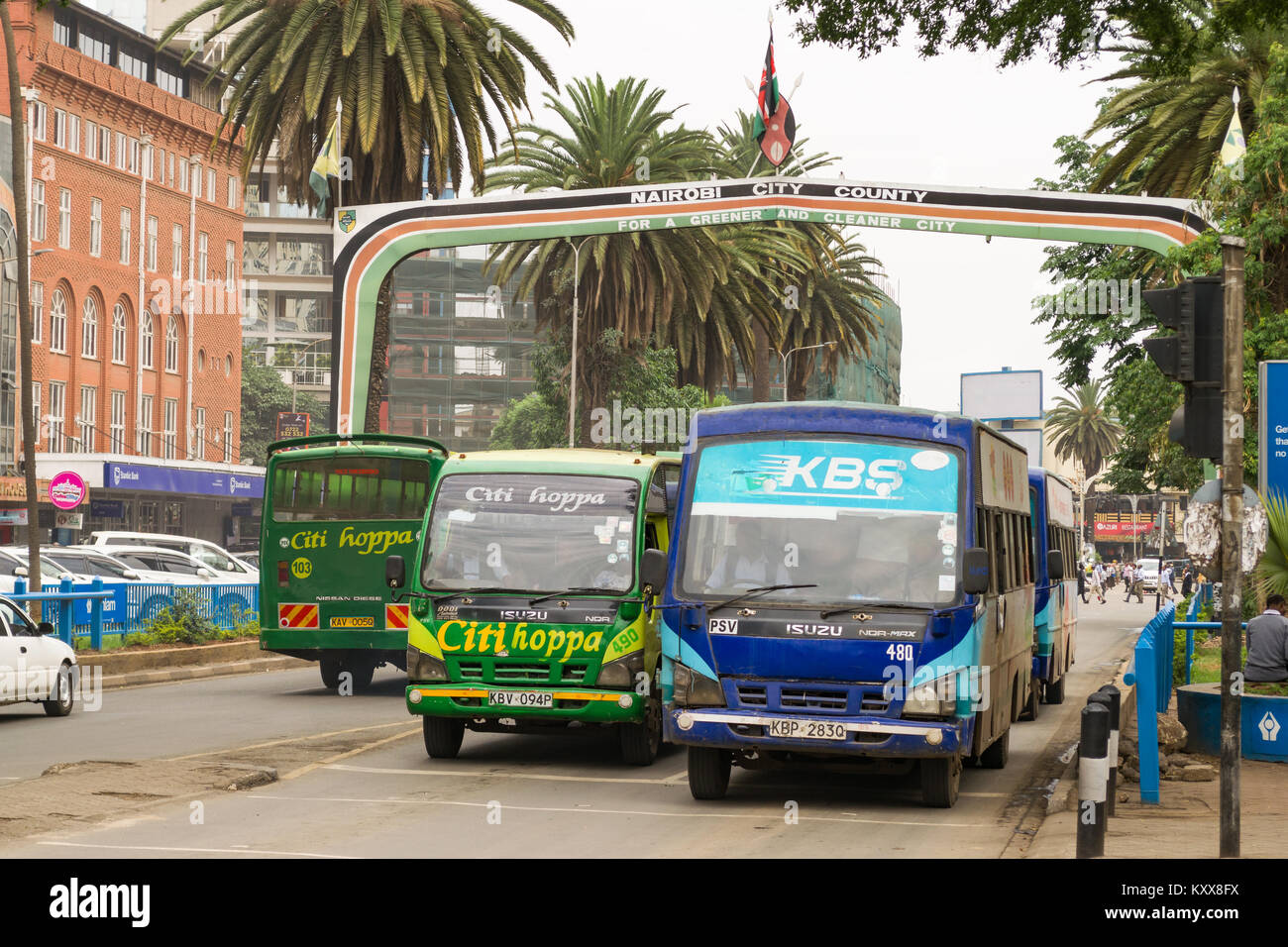 Visualizza in basso Kenyatta Avenue con la città di Nairobi County segno sopra la strada come autobus attendere al semaforo, Nairobi, Kenia Foto Stock