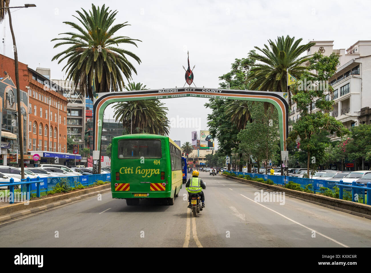 Visualizza in basso Kenyatta Avenue con la città di Nairobi County segno sopra la strada come veicoli auto al di sotto di esso, Nairobi, Kenia Foto Stock