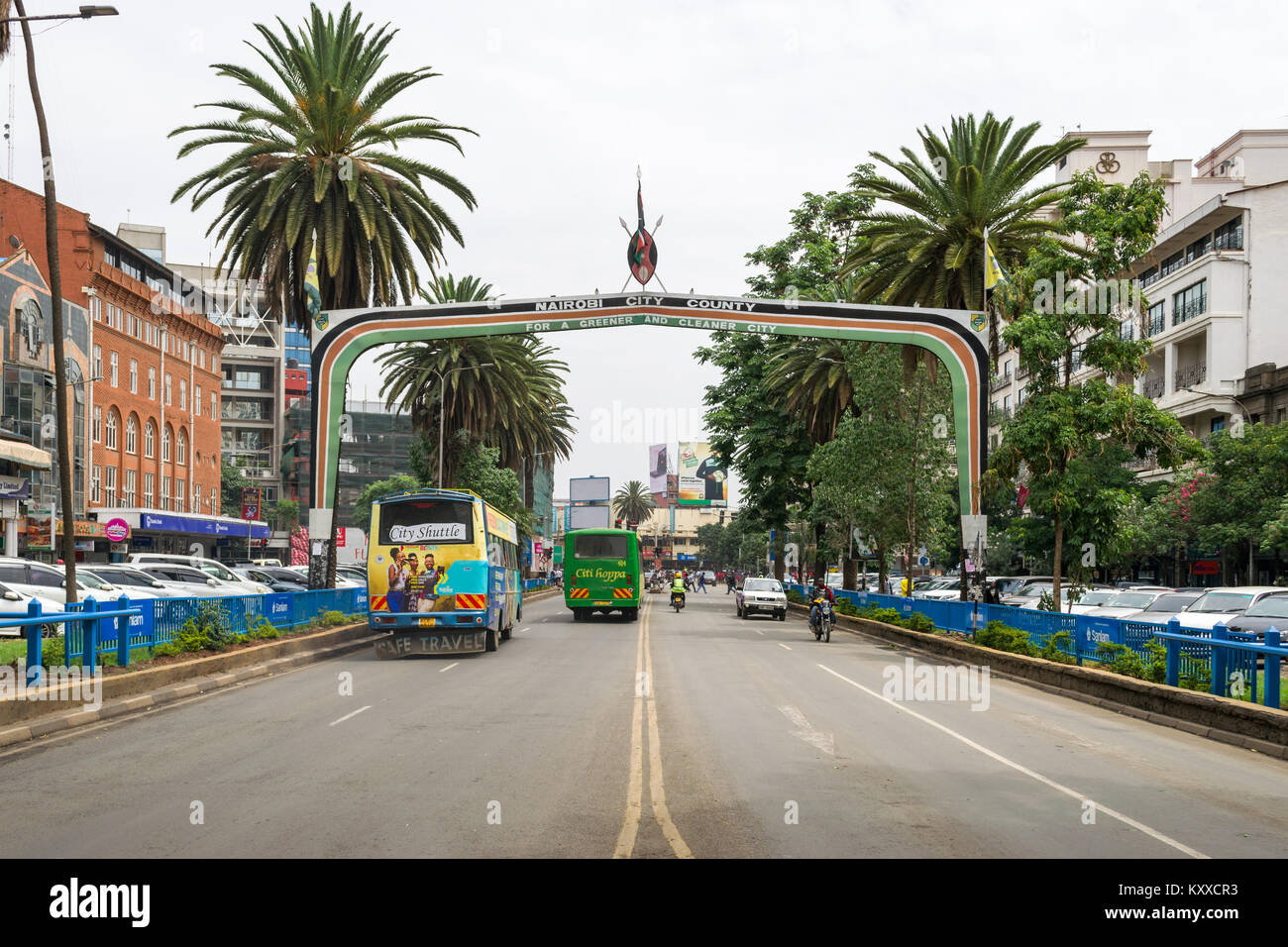 Visualizza in basso Kenyatta Avenue con la città di Nairobi County segno sopra la strada come veicoli auto al di sotto di esso, Nairobi, Kenia Foto Stock