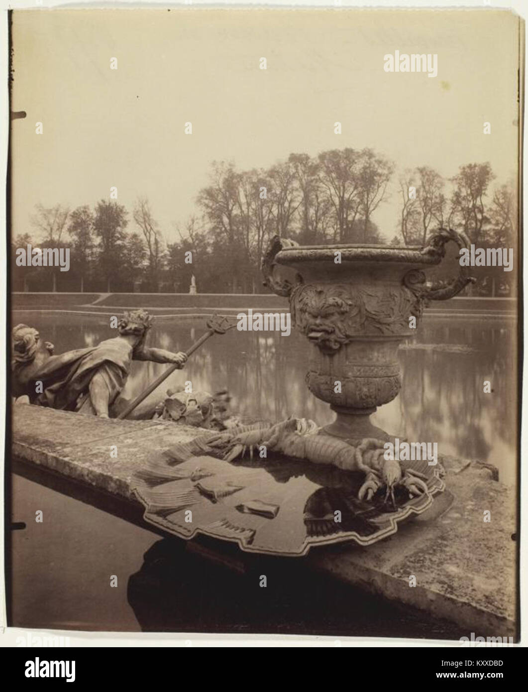 Una fotografia di Eugène Atget che raffigura il bacino di Nettuno alla Reggia di Versailles, in Francia. L'immagine cattura i dettagli scultorei della fontana monumentale e il design simmetrico del paesaggio. Foto Stock