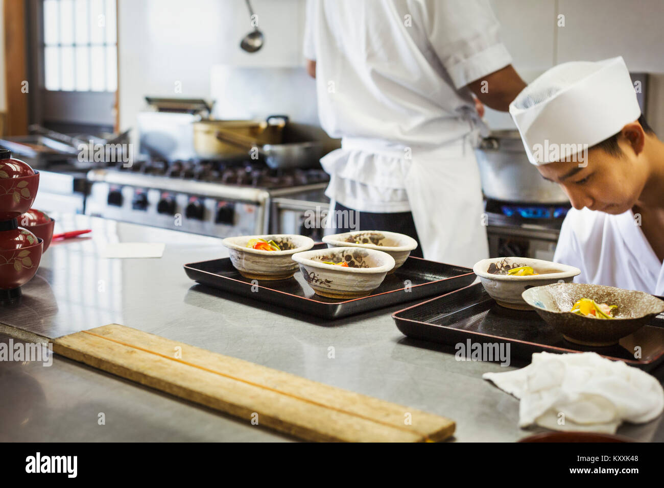 Due chef lavorano a un contatore a un I sushi giapponesi La cucina del ristorante. Foto Stock