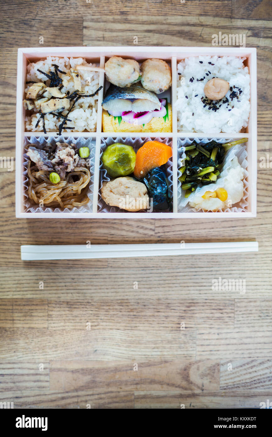 Angolo alto close up di Bento box con il tradizionale cibo giapponese e  bastoncini su di un tavolo di legno Foto stock - Alamy