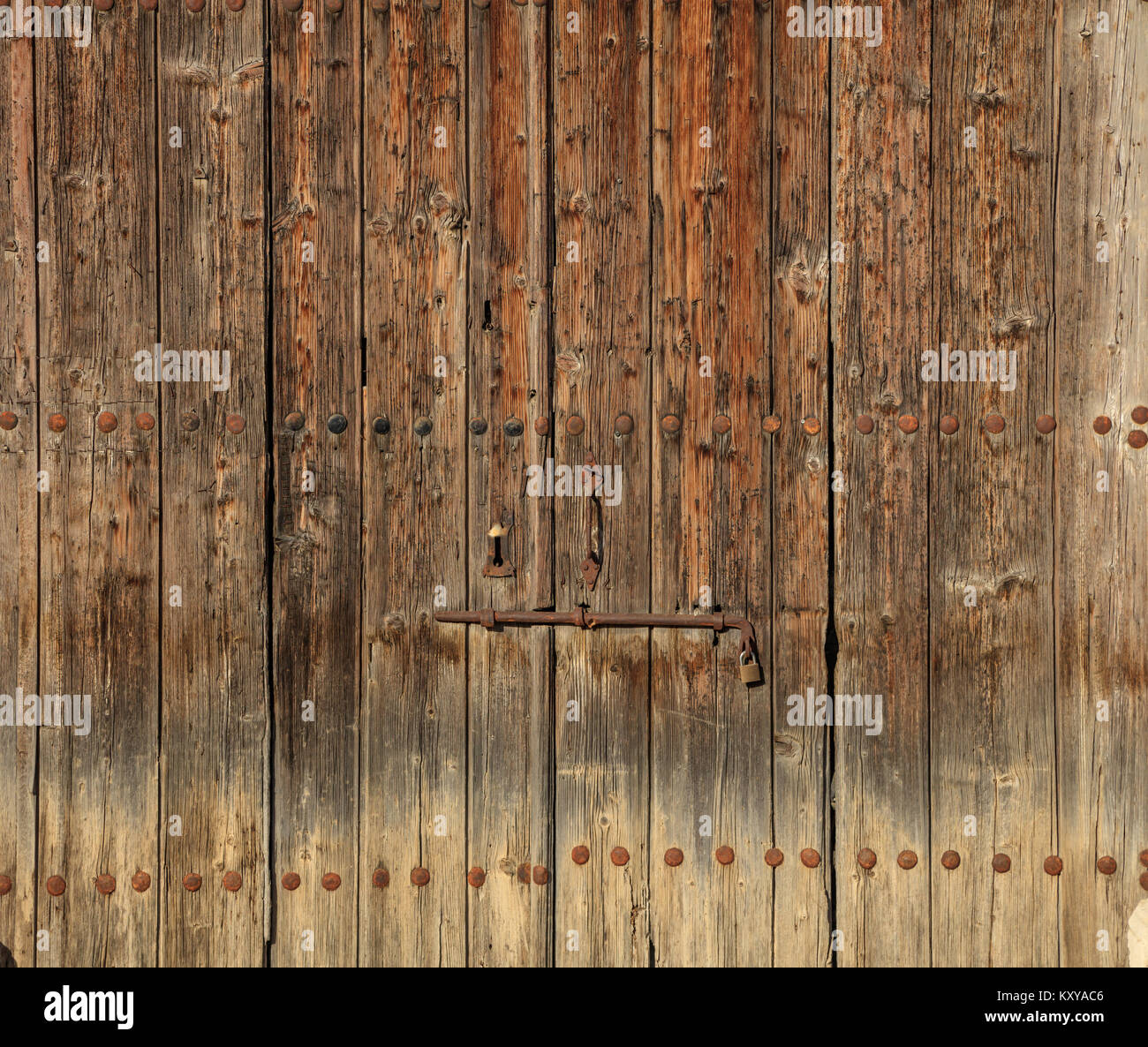 Legno marrone porta. Trito lo sfondo con il chiavistello arrugginito e un lucchetto. Vista ravvicinata con i dettagli. Foto Stock