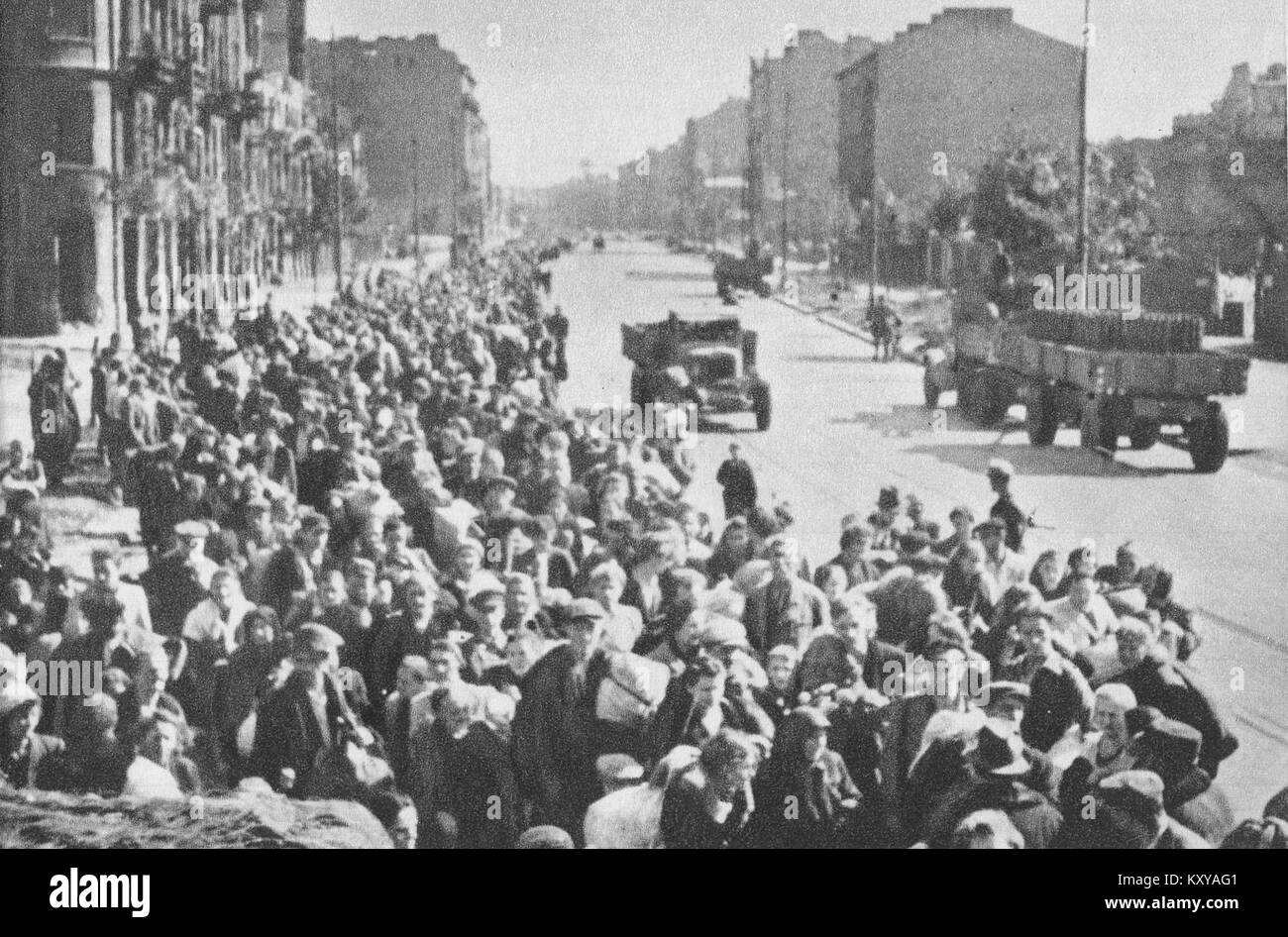 Fotografia che mostra i civili che evacuano Varsavia dopo la capitolazione della rivolta di Varsavia nel 1944. L'immagine cattura uomini, donne e bambini che si muovono sotto la supervisione militare tedesca, raffigurando sfollamenti forzati e sofferenze civili durante la seconda guerra mondiale Foto Stock