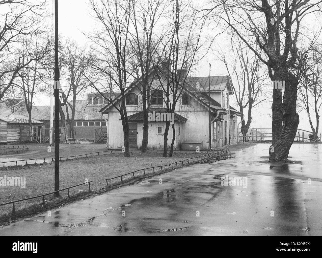 La documentazione del 1965 di Gubbängens Gård, Svezia, mostra una classica casa colonica dipinta di rosso, finestre con finiture bianche e cortile circostante tipico della tradizione architettonica rurale svedese durante la metà del XX secolo. Foto Stock