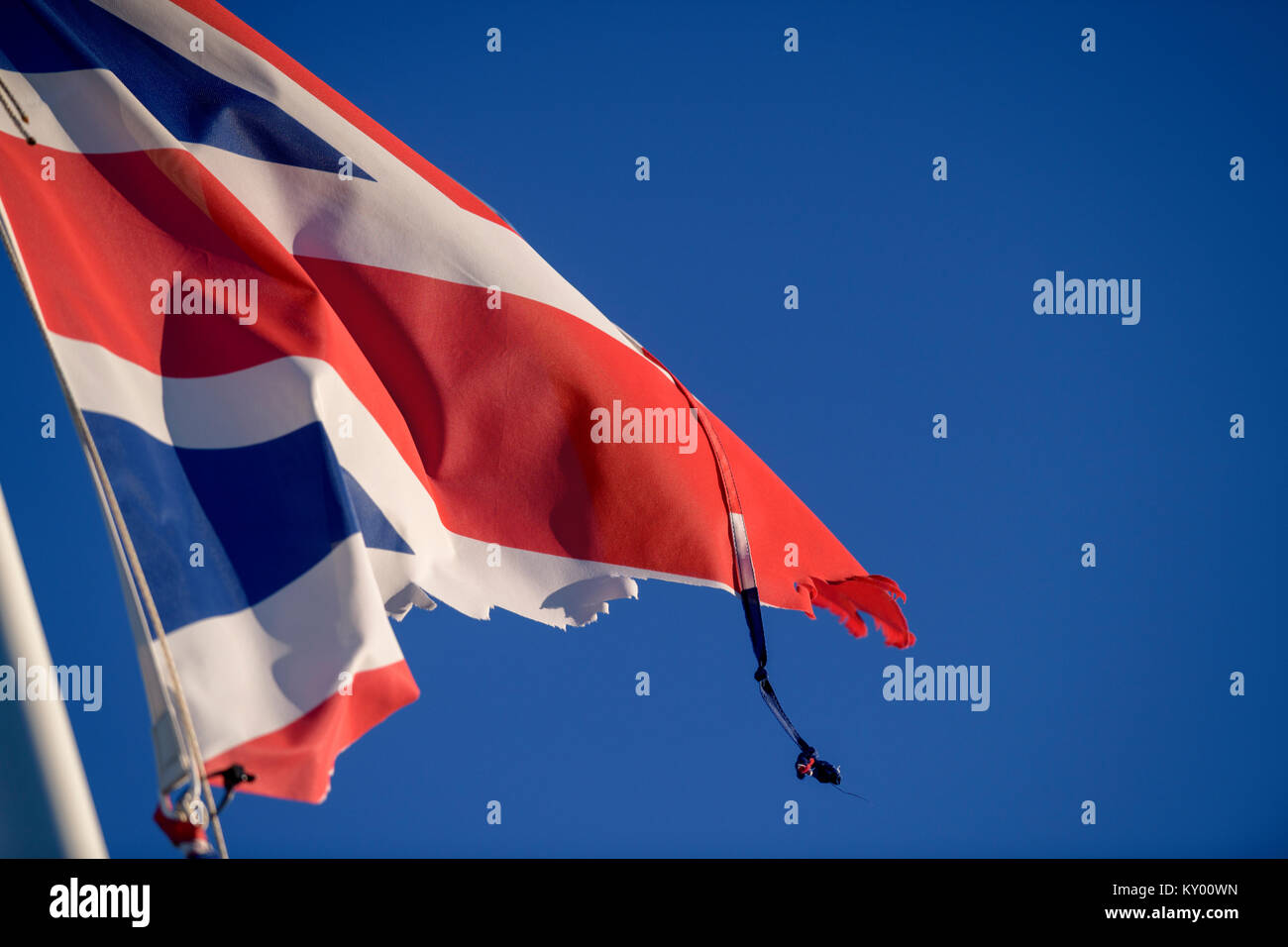 Un vestito di stracci Union Jack flag che fluttua nel vento contro un cielo blu. Foto Stock