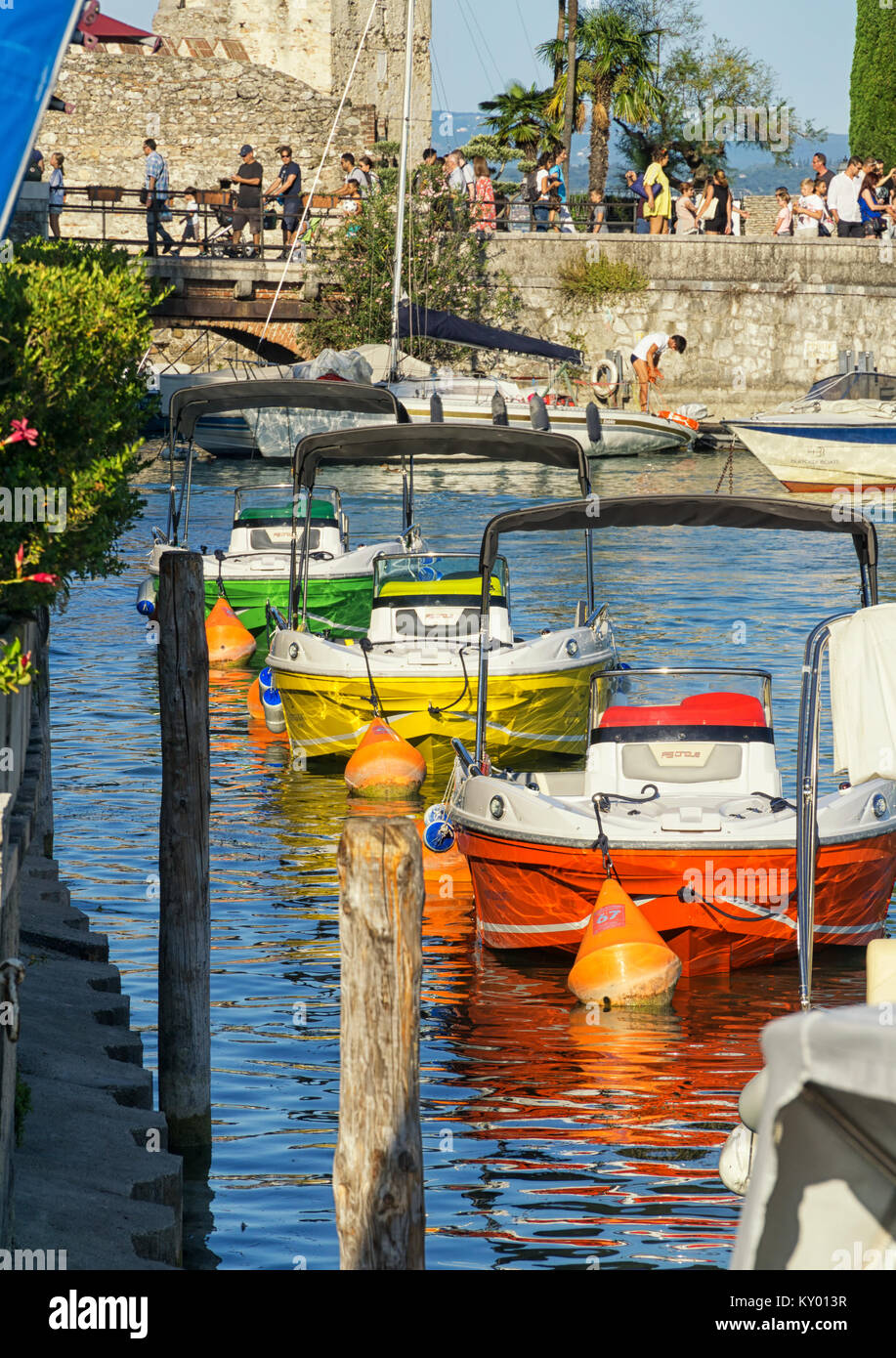 Tre barche colorate ormeggiati a Marina a Sirmione sul Lago di Garda, Italia Foto Stock